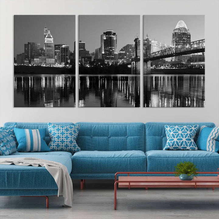 The wall showcases a ready-to-hang triptych of the Cincinnati City Lights Skyline in black and white, printed on museum-quality canvas.