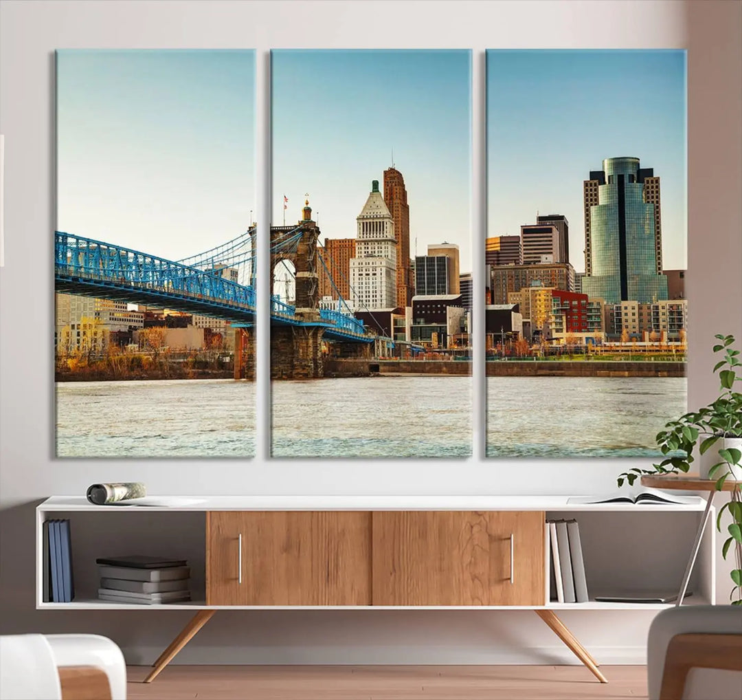 The Cincinnati City Morning Skyline Cityscape View Wall Art Canvas Print features three-panel museum-quality canvases depicting a city skyline with a bridge over a river. This gallery-wrapped artwork ensures an elegant finish and enduring beauty.