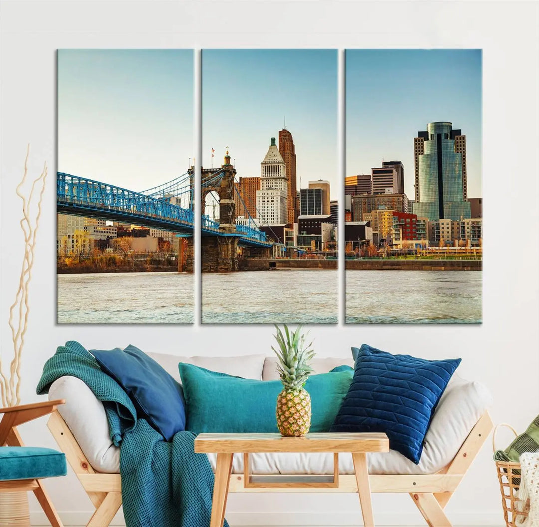 The Cincinnati City Morning Skyline Cityscape View Wall Art Canvas Print features three-panel museum-quality canvases depicting a city skyline with a bridge over a river. This gallery-wrapped artwork ensures an elegant finish and enduring beauty.