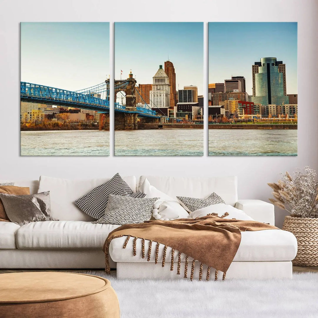 The Cincinnati City Morning Skyline Cityscape View Wall Art Canvas Print features three-panel museum-quality canvases depicting a city skyline with a bridge over a river. This gallery-wrapped artwork ensures an elegant finish and enduring beauty.