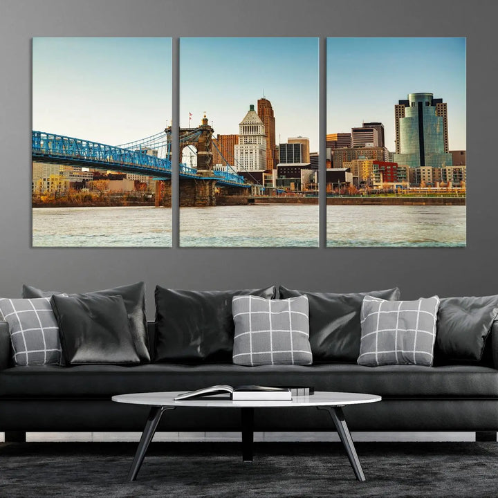 The Cincinnati City Morning Skyline Cityscape View Wall Art Canvas Print features three-panel museum-quality canvases depicting a city skyline with a bridge over a river. This gallery-wrapped artwork ensures an elegant finish and enduring beauty.