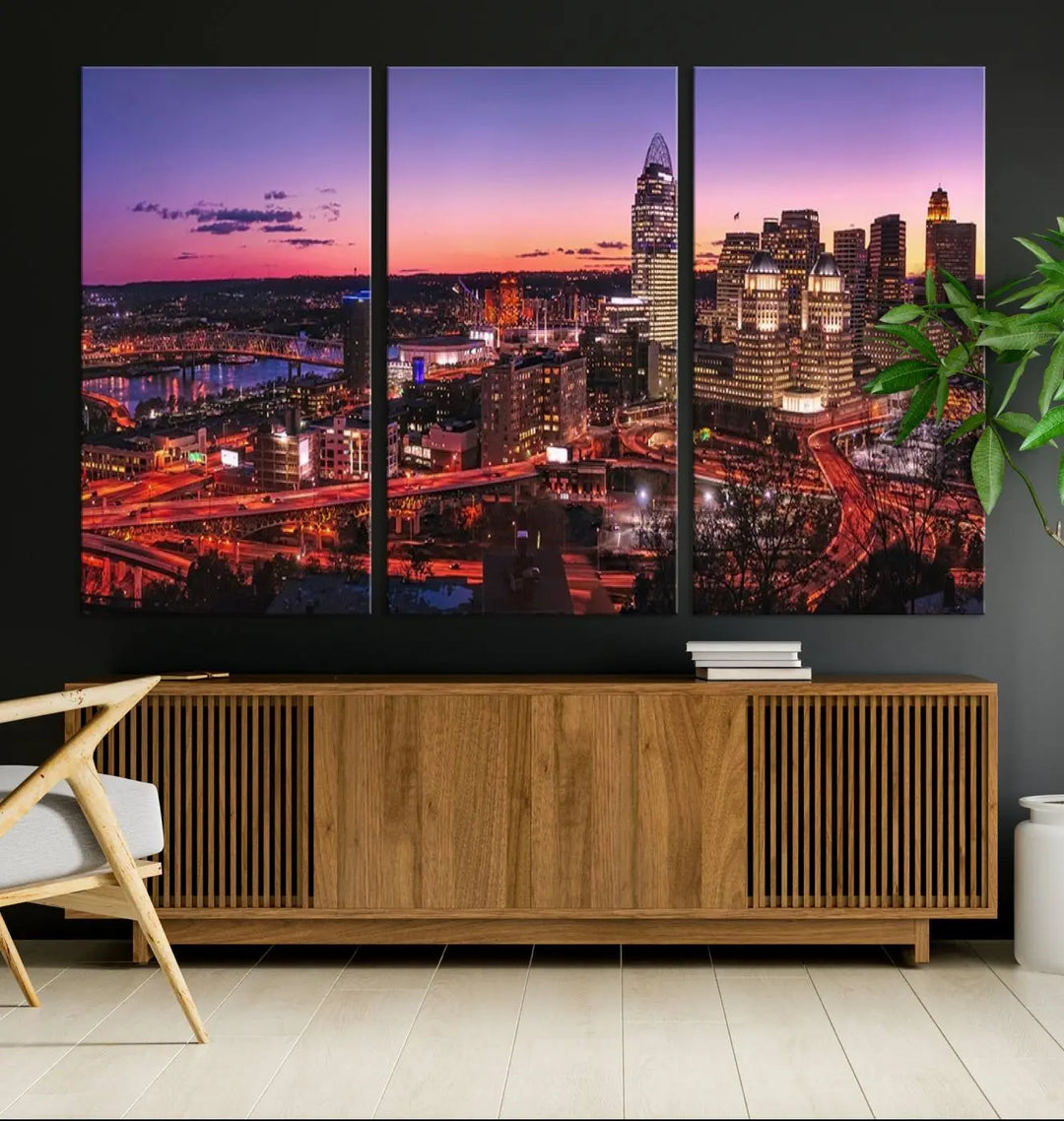 The Cincinnati City Sunset Purple Skyline Cityscape View Wall Art Canvas Print showcases a beautiful cityscape photo at sunset on a gallery-wrapped, museum-quality canvas. It is enhanced with a UV-protective coating to ensure lasting vibrancy and longevity.