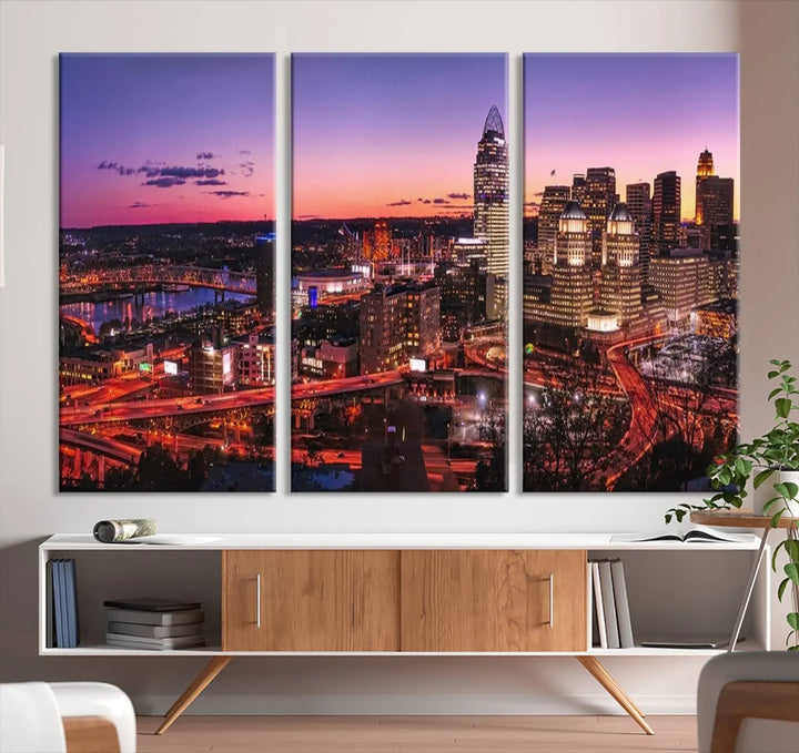 The Cincinnati City Sunset Purple Skyline Cityscape View Wall Art Canvas Print showcases a beautiful cityscape photo at sunset on a gallery-wrapped, museum-quality canvas. It is enhanced with a UV-protective coating to ensure lasting vibrancy and longevity.