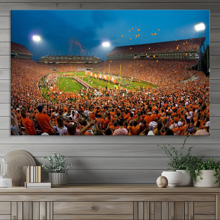 Imagine a stunning wall art canvas that captures the excitement and energy of a large football stadium packed with fans donned in orange. This Clemson University Tigers Football Team Print showcases Clemson Memorial Stadium under vibrant lights, transforming history into an enduring masterpiece.