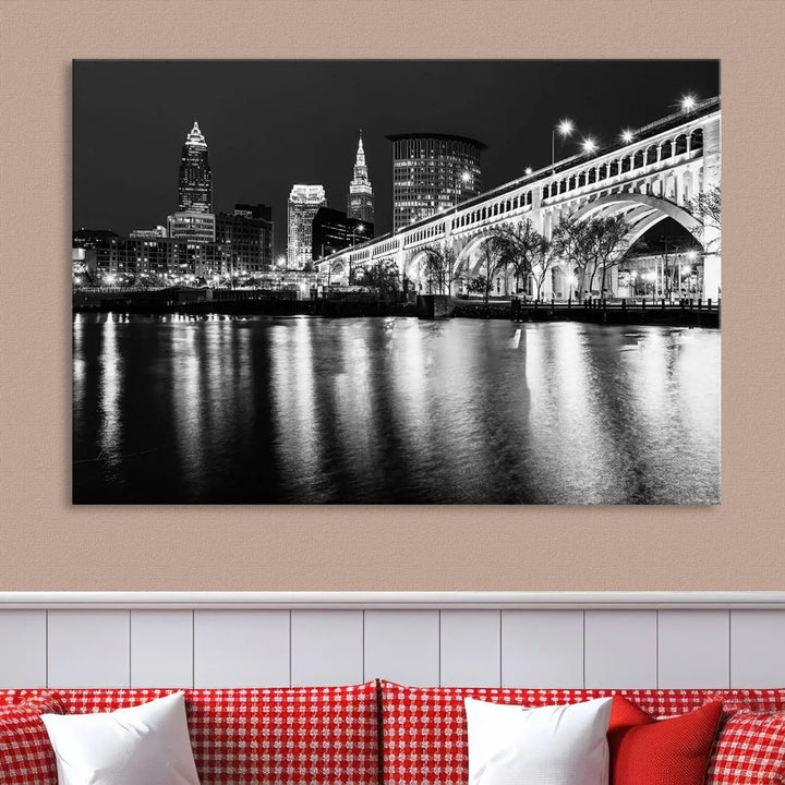 The "Cleveland Night Skyline Wall Art City Cityscape Canvas Print" is displayed in a black-and-white triptych on a gray wall. This gallery-wrapped artwork is printed on museum-quality canvas with a UV-protective coating, ensuring its striking details remain preserved for years.