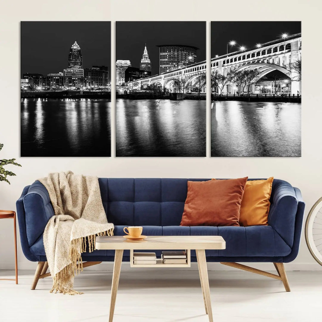 The "Cleveland Night Skyline Wall Art City Cityscape Canvas Print" is displayed in a black-and-white triptych on a gray wall. This gallery-wrapped artwork is printed on museum-quality canvas with a UV-protective coating, ensuring its striking details remain preserved for years.