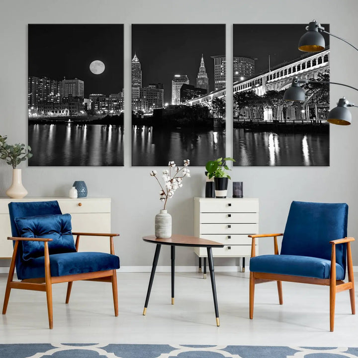 A modern living room features the "Cleveland Night Skyline Wall Art City Cityscape Canvas Print" on the wall, showcasing a moonlit skyline and river. It is professionally gallery wrapped on museum-quality canvas for enduring elegance.