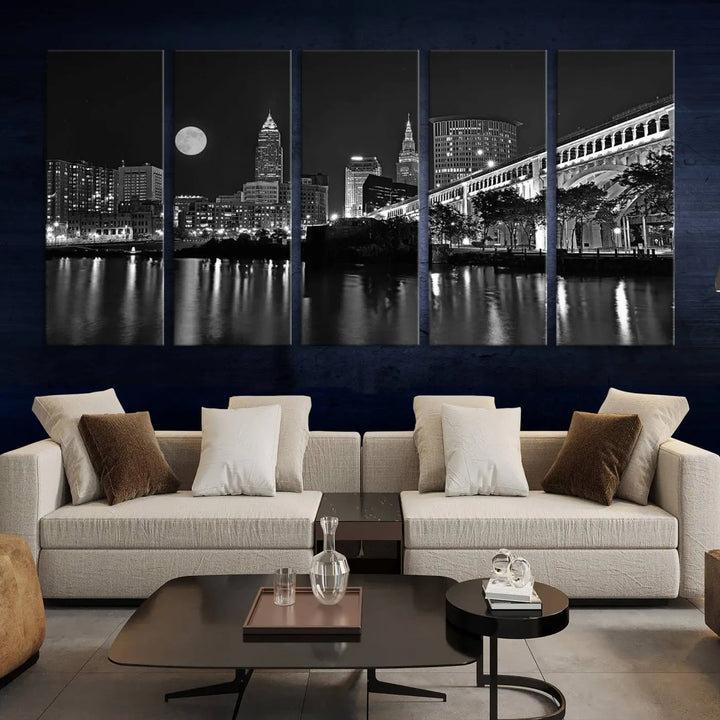 A modern living room features the "Cleveland Night Skyline Wall Art City Cityscape Canvas Print" on the wall, showcasing a moonlit skyline and river. It is professionally gallery wrapped on museum-quality canvas for enduring elegance.