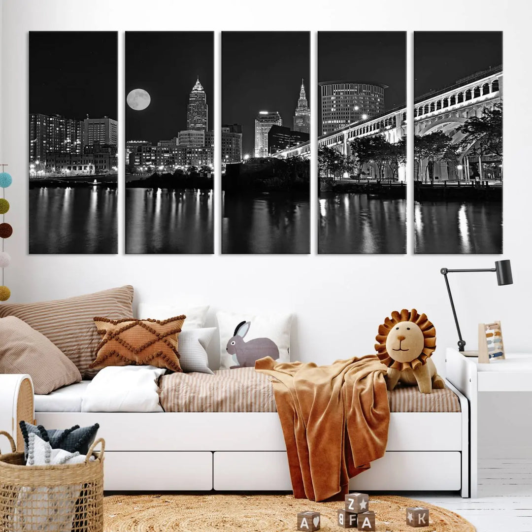 A modern living room features the "Cleveland Night Skyline Wall Art City Cityscape Canvas Print" on the wall, showcasing a moonlit skyline and river. It is professionally gallery wrapped on museum-quality canvas for enduring elegance.