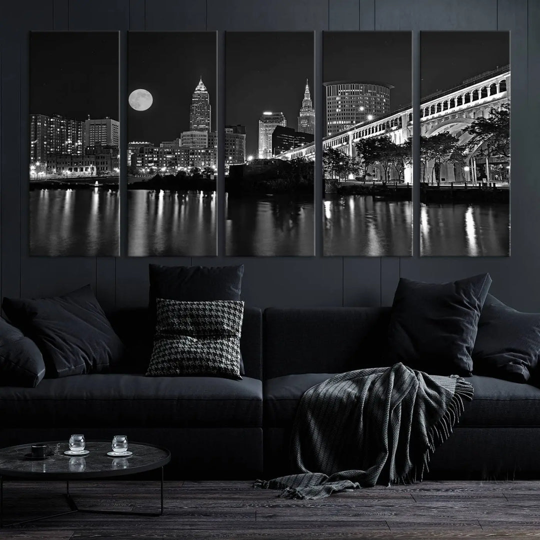 A modern living room features the "Cleveland Night Skyline Wall Art City Cityscape Canvas Print" on the wall, showcasing a moonlit skyline and river. It is professionally gallery wrapped on museum-quality canvas for enduring elegance.