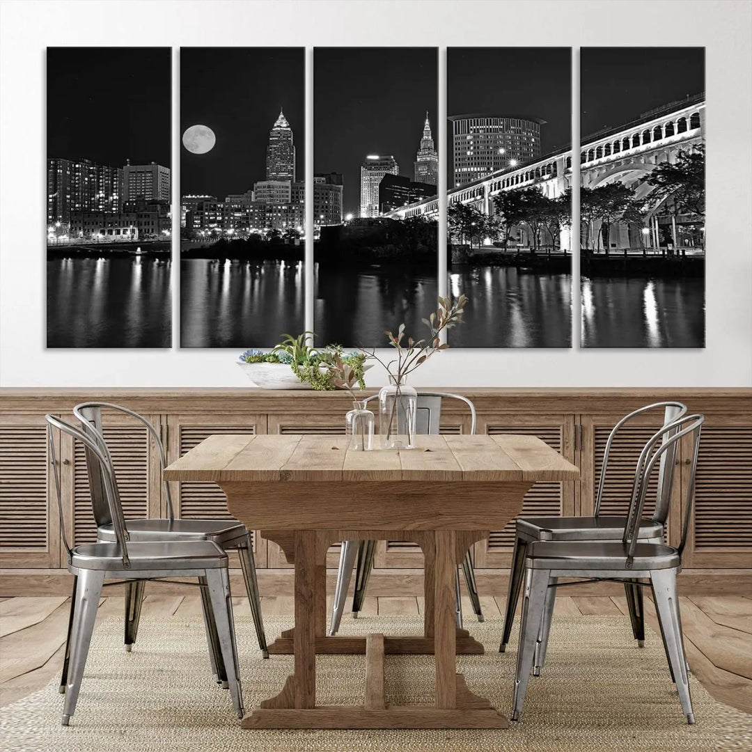 A modern living room features the "Cleveland Night Skyline Wall Art City Cityscape Canvas Print" on the wall, showcasing a moonlit skyline and river. It is professionally gallery wrapped on museum-quality canvas for enduring elegance.