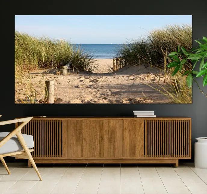 The Coastal Beach Print, showcasing a pathway to beach dunes with grass, is elegantly displayed on a gallery-wrapped museum-quality canvas. This ocean wall art canvas print features a UV-protective coating for enduring beauty.