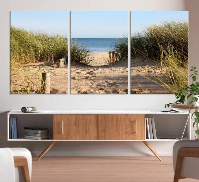 The Coastal Beach Print, showcasing a pathway to beach dunes with grass, is elegantly displayed on a gallery-wrapped museum-quality canvas. This ocean wall art canvas print features a UV-protective coating for enduring beauty.