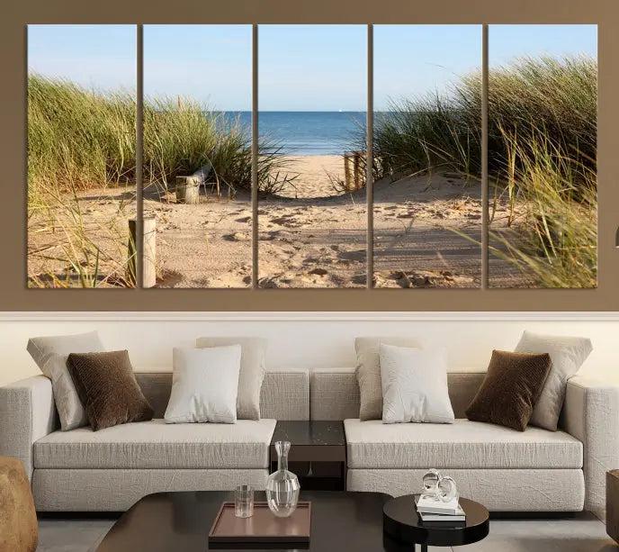 The Coastal Beach Print, showcasing a pathway to beach dunes with grass, is elegantly displayed on a gallery-wrapped museum-quality canvas. This ocean wall art canvas print features a UV-protective coating for enduring beauty.