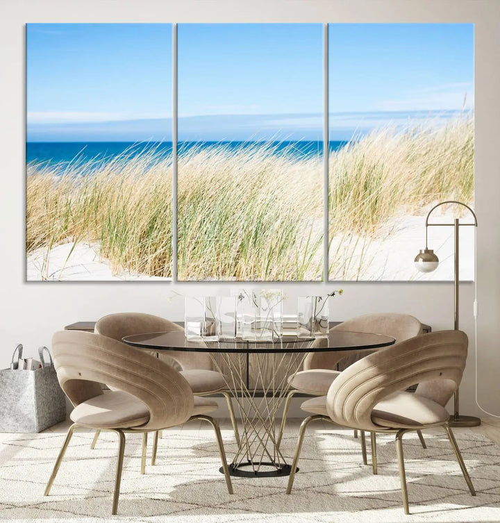 The Coastal Ocean Beach Wall Art Canvas Print, featuring a three-panel design with beach grass and an ocean view on museum-quality canvas, enhances the space in a modern living room. The artwork is ready to hang and comes with a UV-protective coating for enduring beauty.