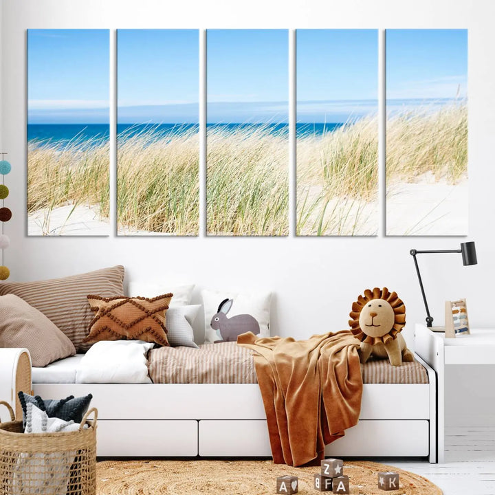 The Coastal Ocean Beach Wall Art Canvas Print, featuring a three-panel design with beach grass and an ocean view on museum-quality canvas, enhances the space in a modern living room. The artwork is ready to hang and comes with a UV-protective coating for enduring beauty.