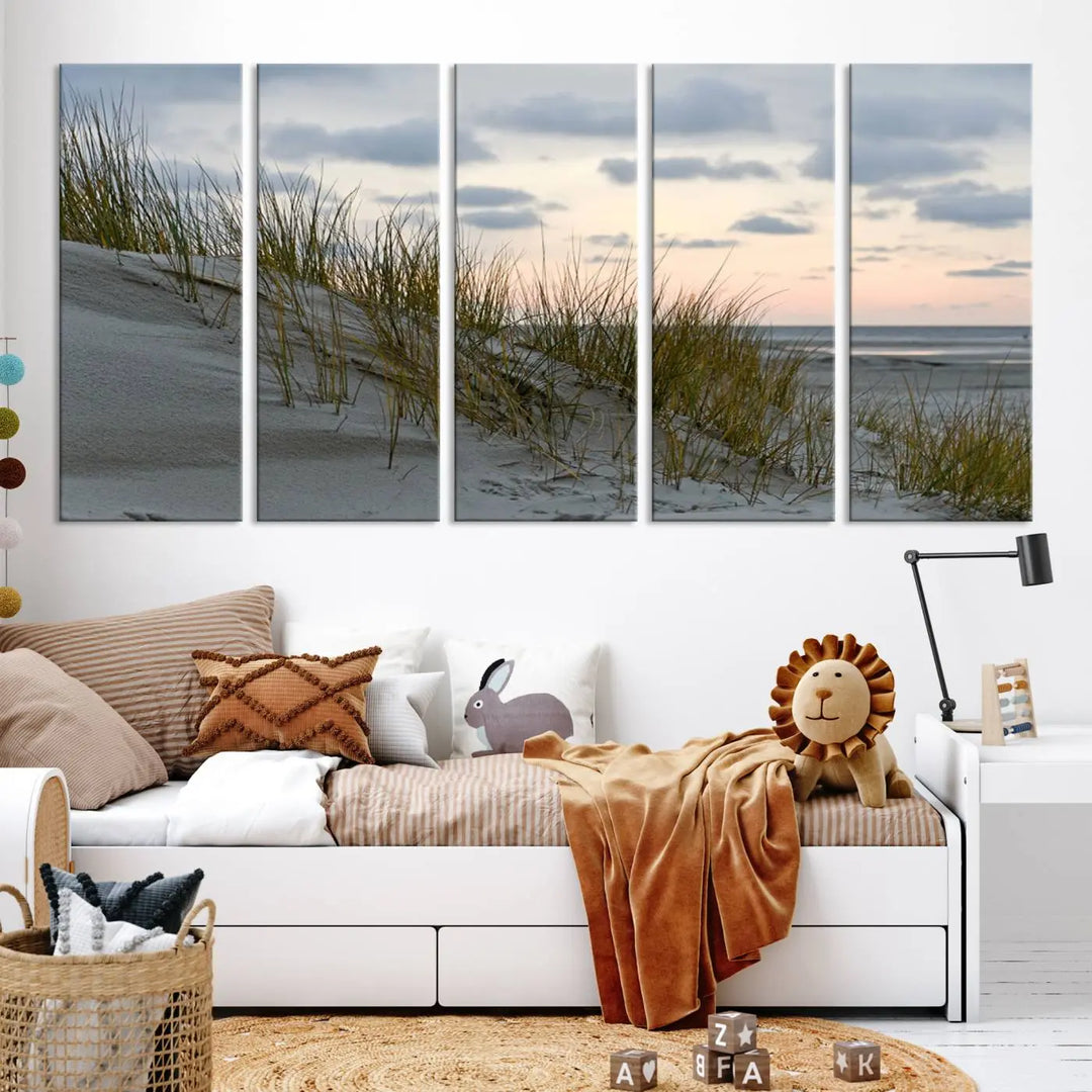 The Coastal Ocean Landscape Beach Wall Art Canvas Print is a triptych depicting sandy dunes and grass at sunset. It arrives ready to hang and is equipped with a UV-protective coating for lasting vibrancy and protection against fading sunlight.