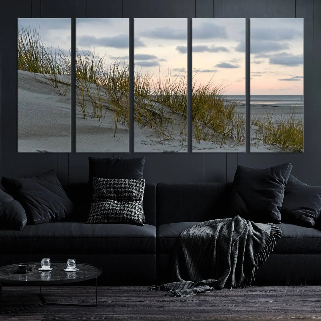 The Coastal Ocean Landscape Beach Wall Art Canvas Print is a triptych depicting sandy dunes and grass at sunset. It arrives ready to hang and is equipped with a UV-protective coating for lasting vibrancy and protection against fading sunlight.