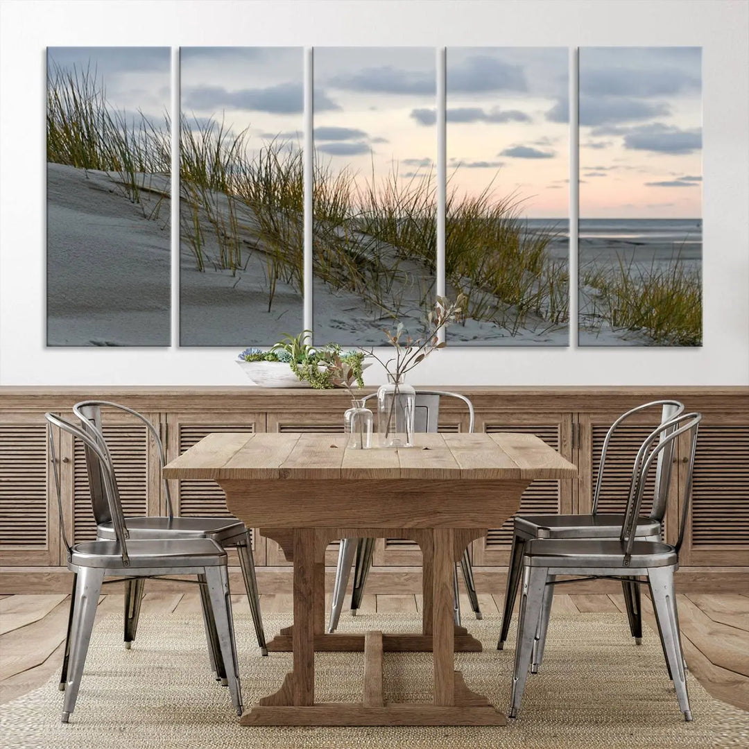 The Coastal Ocean Landscape Beach Wall Art Canvas Print is a triptych depicting sandy dunes and grass at sunset. It arrives ready to hang and is equipped with a UV-protective coating for lasting vibrancy and protection against fading sunlight.