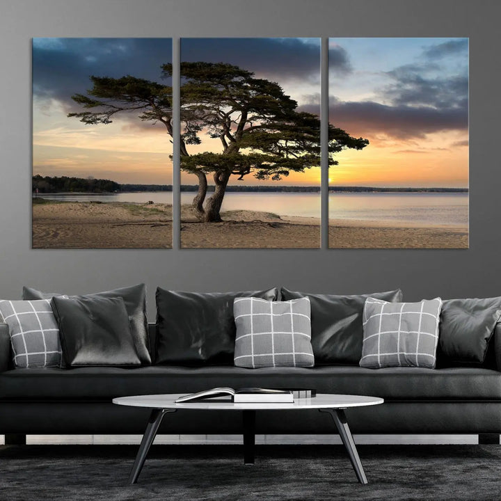 The room showcases the Coastal Sunset Wall Art Canvas Print, a triptych elegantly displayed on museum-quality polycotton canvas, depicting a serene beach sunset with a tree.