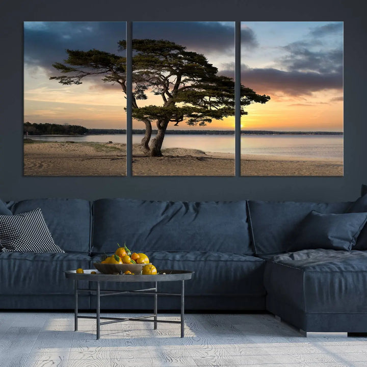 The room showcases the Coastal Sunset Wall Art Canvas Print, a triptych elegantly displayed on museum-quality polycotton canvas, depicting a serene beach sunset with a tree.