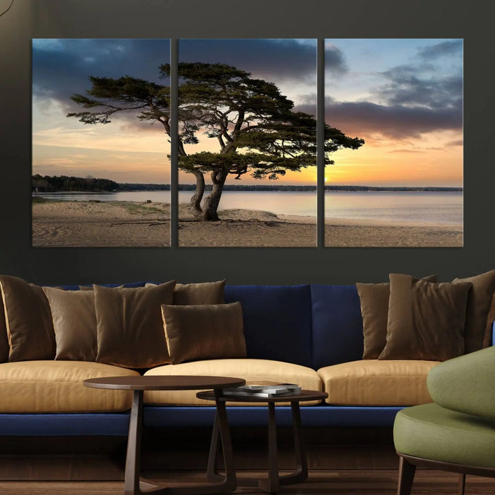 The room showcases the Coastal Sunset Wall Art Canvas Print, a triptych elegantly displayed on museum-quality polycotton canvas, depicting a serene beach sunset with a tree.