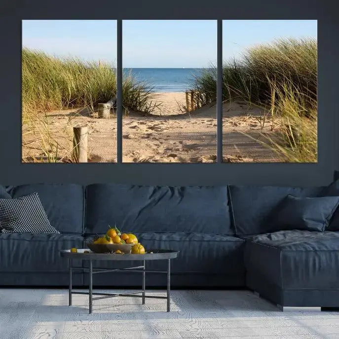 The Coastal Wall Art Beach Pathway Canvas Print creates a tranquil atmosphere, featuring a scenic sandy beach path lined with tall grass leading to the ocean.