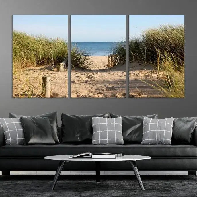 The Coastal Wall Art Beach Pathway Canvas Print creates a tranquil atmosphere, featuring a scenic sandy beach path lined with tall grass leading to the ocean.