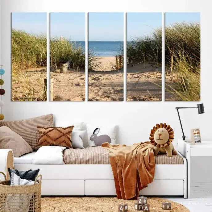 The Coastal Wall Art Beach Pathway Canvas Print creates a tranquil atmosphere, featuring a scenic sandy beach path lined with tall grass leading to the ocean.