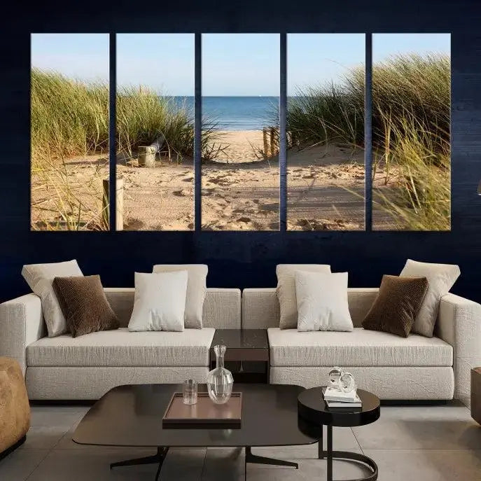 The Coastal Wall Art Beach Pathway Canvas Print creates a tranquil atmosphere, featuring a scenic sandy beach path lined with tall grass leading to the ocean.