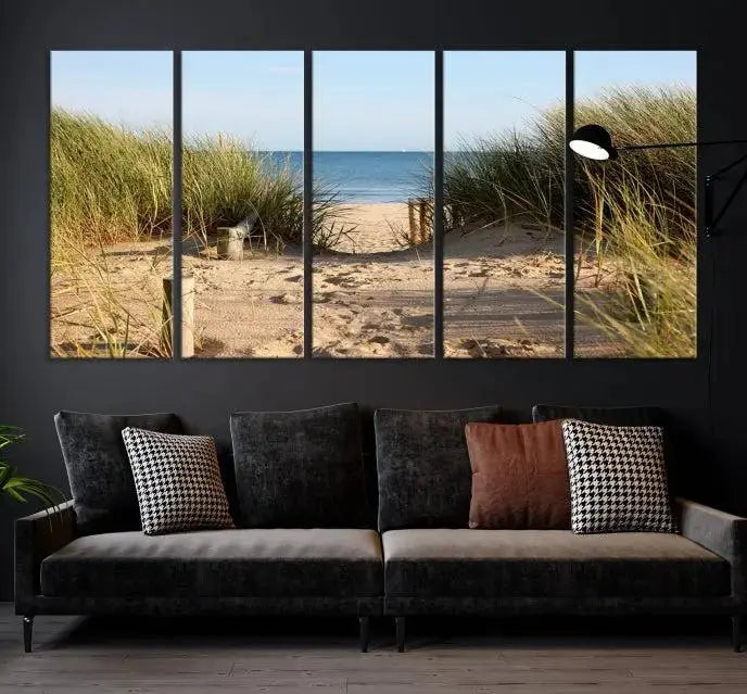 The Coastal Wall Art Beach Pathway Canvas Print creates a tranquil atmosphere, featuring a scenic sandy beach path lined with tall grass leading to the ocean.