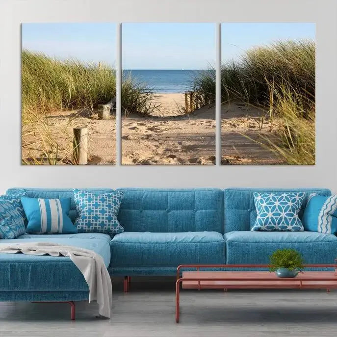 The Coastal Wall Art Beach Pathway Canvas Print creates a tranquil atmosphere, featuring a scenic sandy beach path lined with tall grass leading to the ocean.