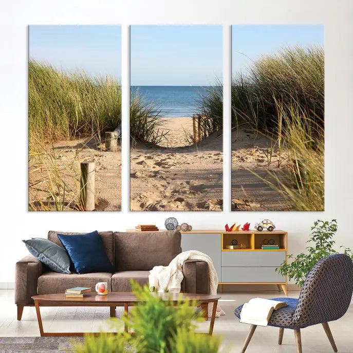 The Coastal Wall Art Beach Pathway Canvas Print creates a tranquil atmosphere, featuring a scenic sandy beach path lined with tall grass leading to the ocean.