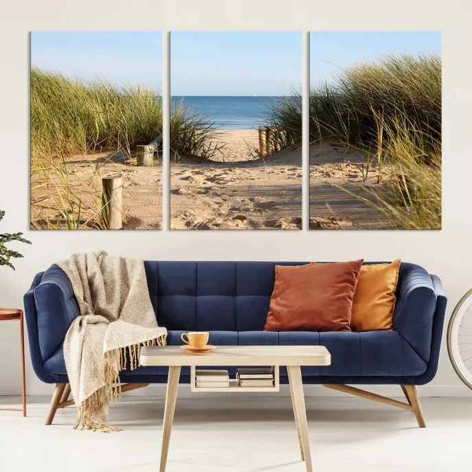 The Coastal Wall Art Beach Pathway Canvas Print creates a tranquil atmosphere, featuring a scenic sandy beach path lined with tall grass leading to the ocean.