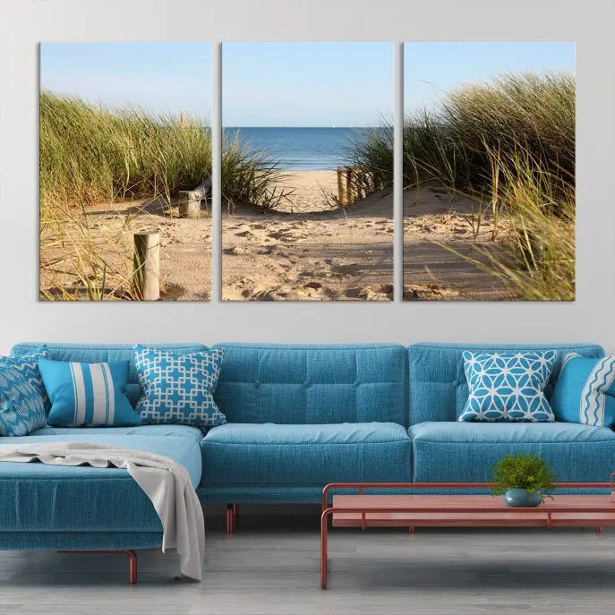 The Coastal Wall Art Beach Pathway Canvas Print creates a tranquil atmosphere, featuring a scenic sandy beach path lined with tall grass leading to the ocean.