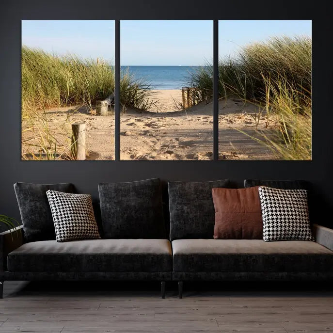 The Coastal Wall Art Beach Pathway Canvas Print creates a tranquil atmosphere, featuring a scenic sandy beach path lined with tall grass leading to the ocean.