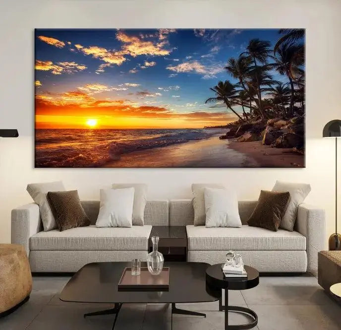 A Coastal Wall Art Beach at Sunset Canvas Print, featuring a triptych of a tropical sunset over the ocean with palm trees, graces the room.