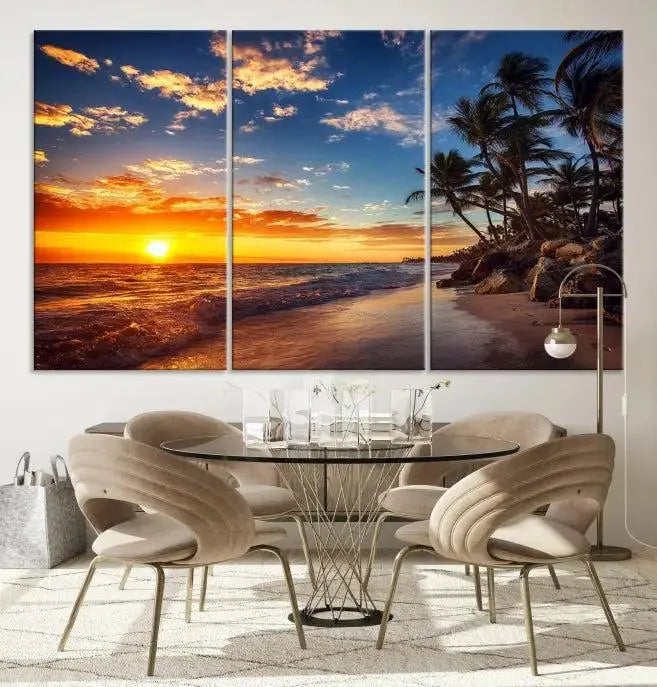 A Coastal Wall Art Beach at Sunset Canvas Print, featuring a triptych of a tropical sunset over the ocean with palm trees, graces the room.