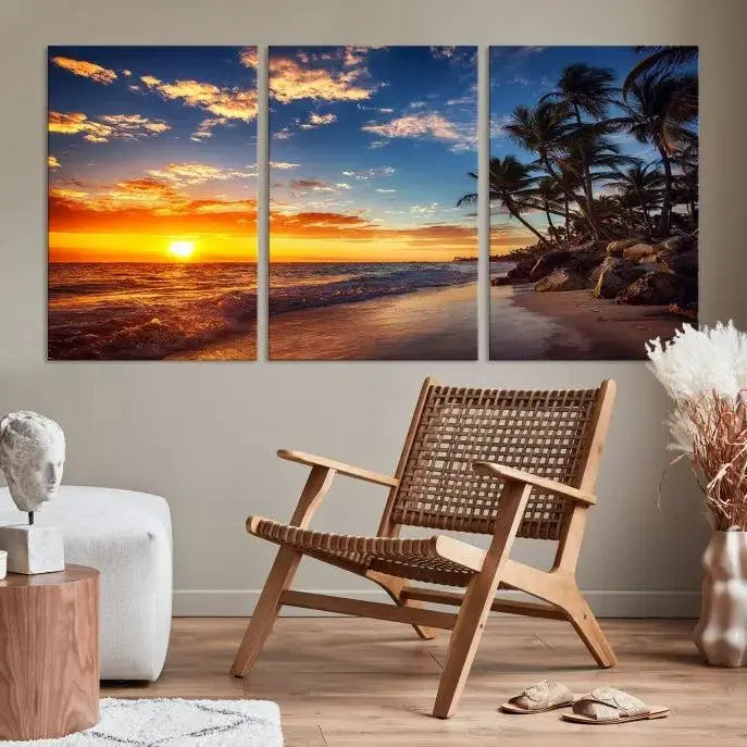 A Coastal Wall Art Beach at Sunset Canvas Print, featuring a triptych of a tropical sunset over the ocean with palm trees, graces the room.