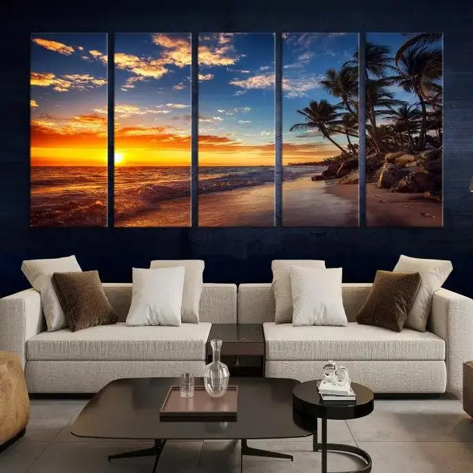 A Coastal Wall Art Beach at Sunset Canvas Print, featuring a triptych of a tropical sunset over the ocean with palm trees, graces the room.