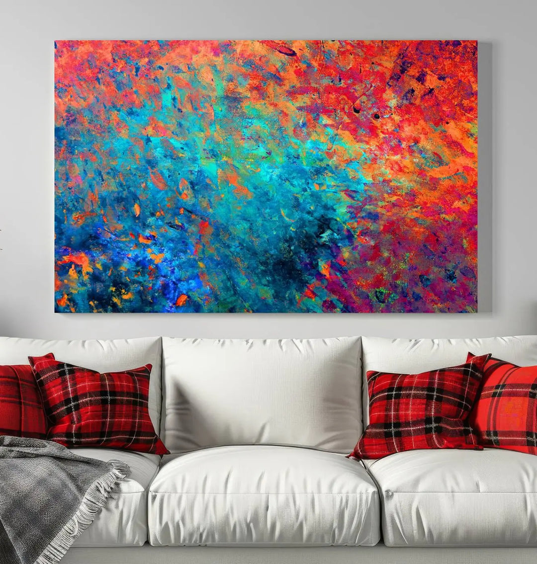 A three-part Colorful Abstract Canvas Wall Art Print, featuring vivid splashes of blue, orange, and red, is showcased on gallery-wrapped, museum-quality canvas with a UV-protective coating.