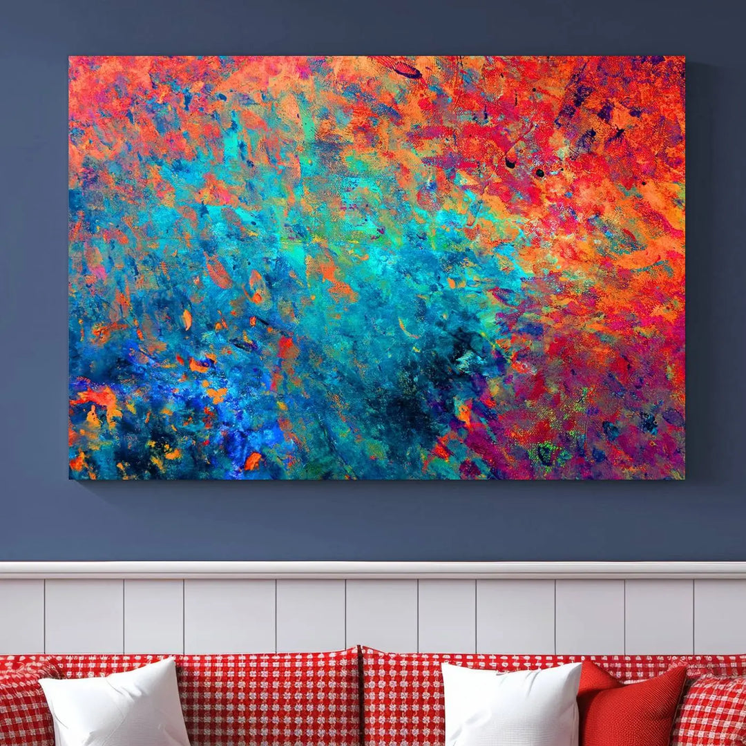 A three-part Colorful Abstract Canvas Wall Art Print, featuring vivid splashes of blue, orange, and red, is showcased on gallery-wrapped, museum-quality canvas with a UV-protective coating.