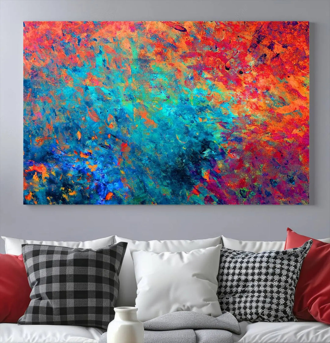 A three-part Colorful Abstract Canvas Wall Art Print, featuring vivid splashes of blue, orange, and red, is showcased on gallery-wrapped, museum-quality canvas with a UV-protective coating.