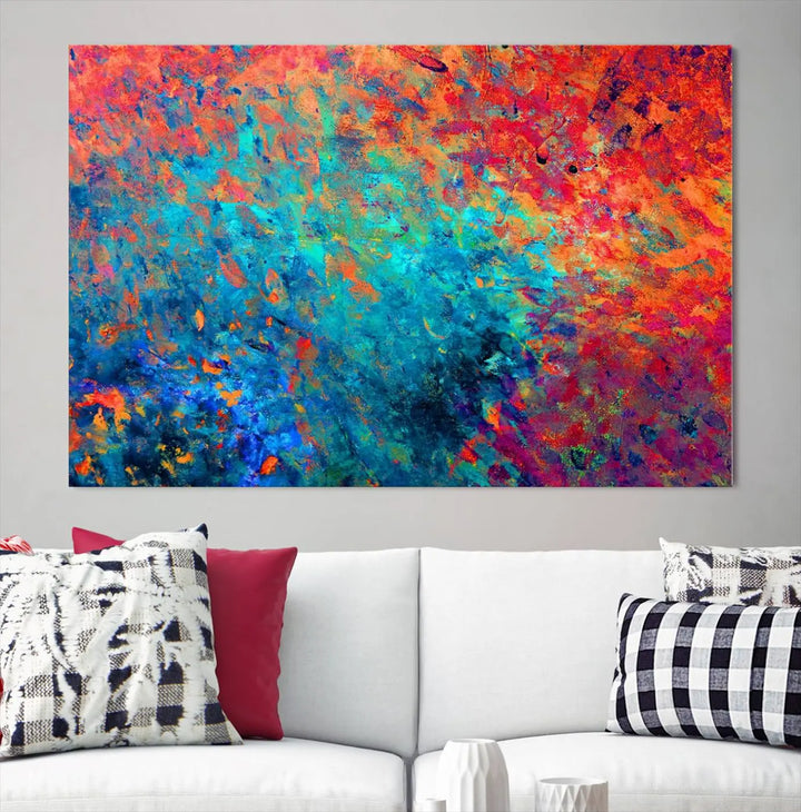 A three-part Colorful Abstract Canvas Wall Art Print, featuring vivid splashes of blue, orange, and red, is showcased on gallery-wrapped, museum-quality canvas with a UV-protective coating.