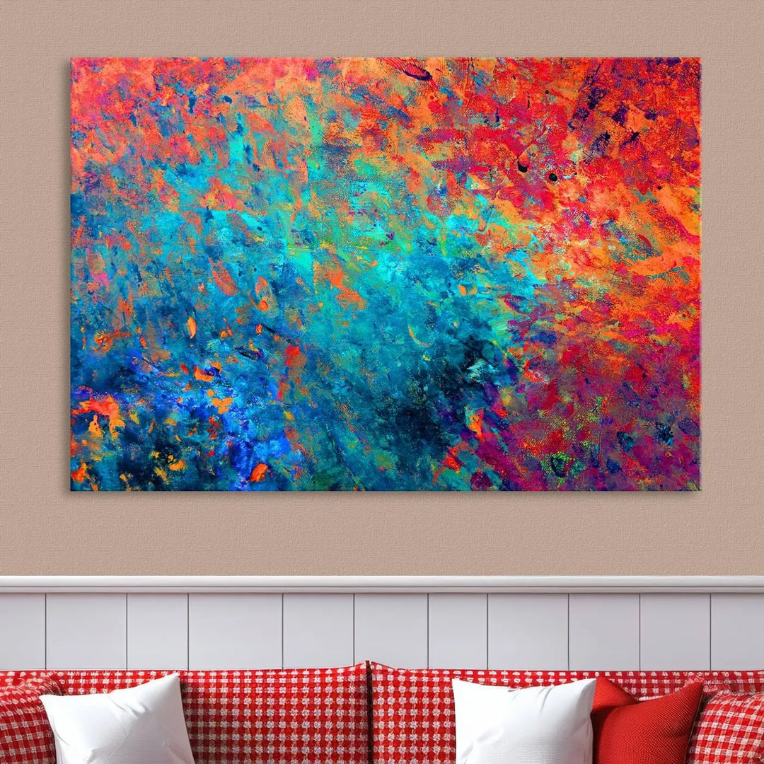 A three-part Colorful Abstract Canvas Wall Art Print, featuring vivid splashes of blue, orange, and red, is showcased on gallery-wrapped, museum-quality canvas with a UV-protective coating.