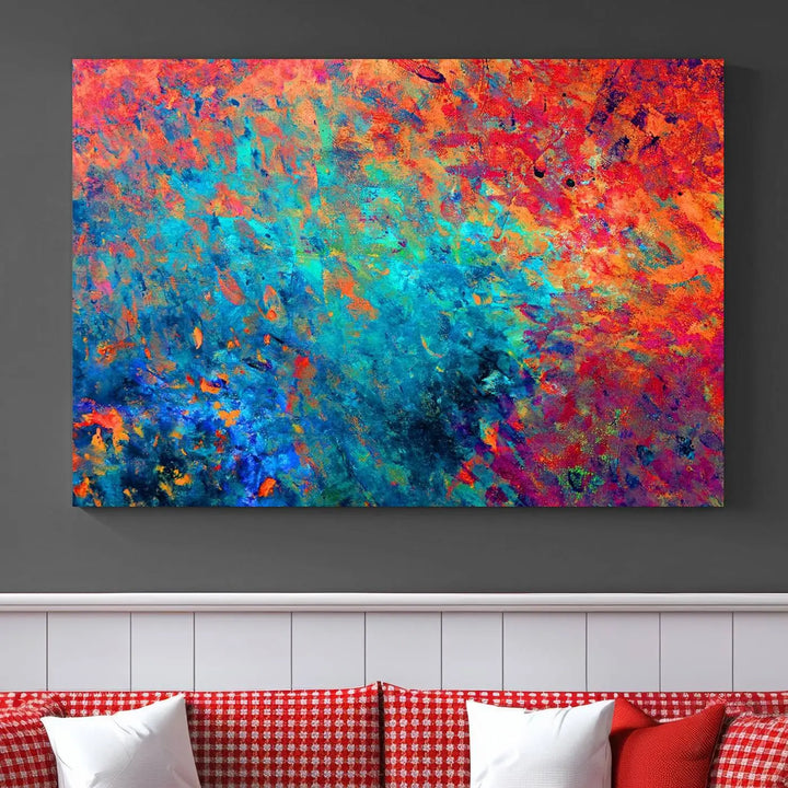 A three-part Colorful Abstract Canvas Wall Art Print, featuring vivid splashes of blue, orange, and red, is showcased on gallery-wrapped, museum-quality canvas with a UV-protective coating.