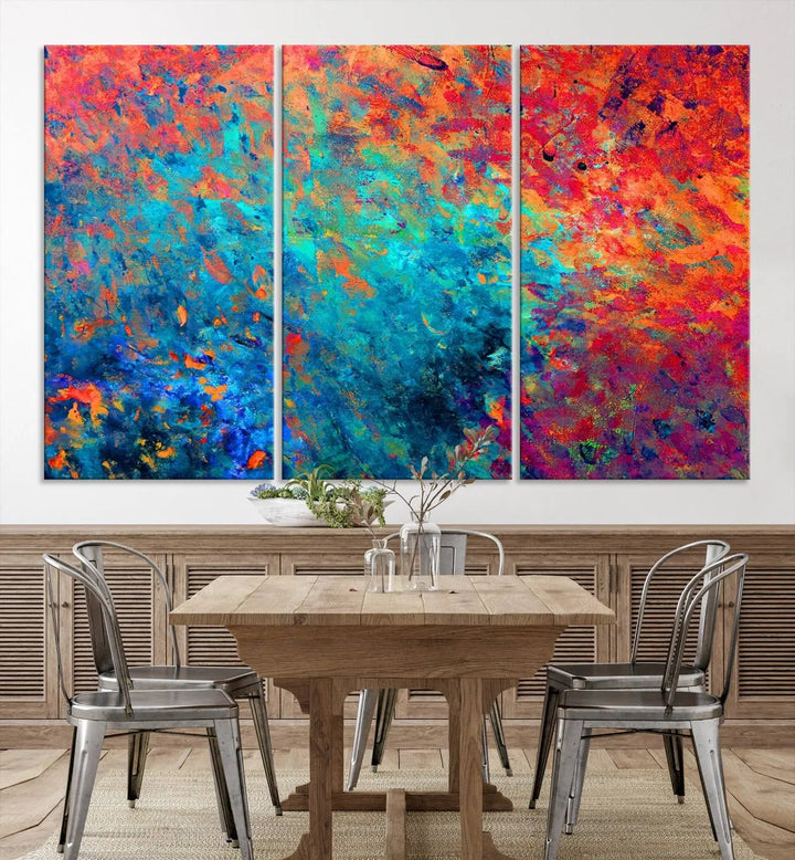 A three-part Colorful Abstract Canvas Wall Art Print, featuring vivid splashes of blue, orange, and red, is showcased on gallery-wrapped, museum-quality canvas with a UV-protective coating.