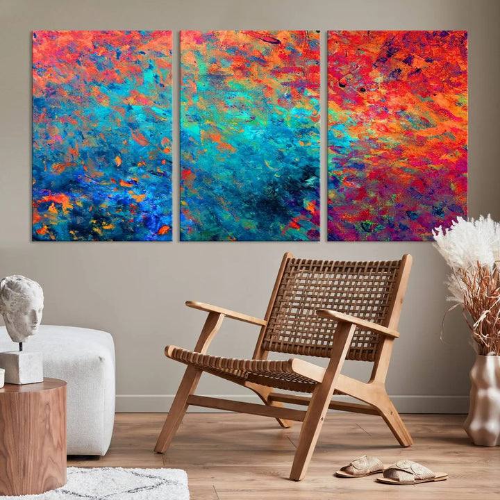 A three-part Colorful Abstract Canvas Wall Art Print, featuring vivid splashes of blue, orange, and red, is showcased on gallery-wrapped, museum-quality canvas with a UV-protective coating.