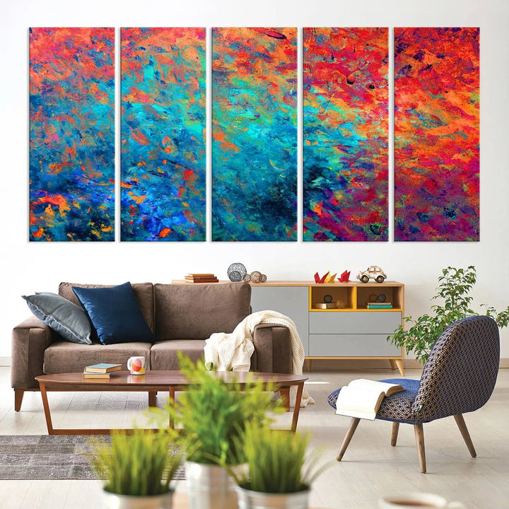 A three-part Colorful Abstract Canvas Wall Art Print, featuring vivid splashes of blue, orange, and red, is showcased on gallery-wrapped, museum-quality canvas with a UV-protective coating.