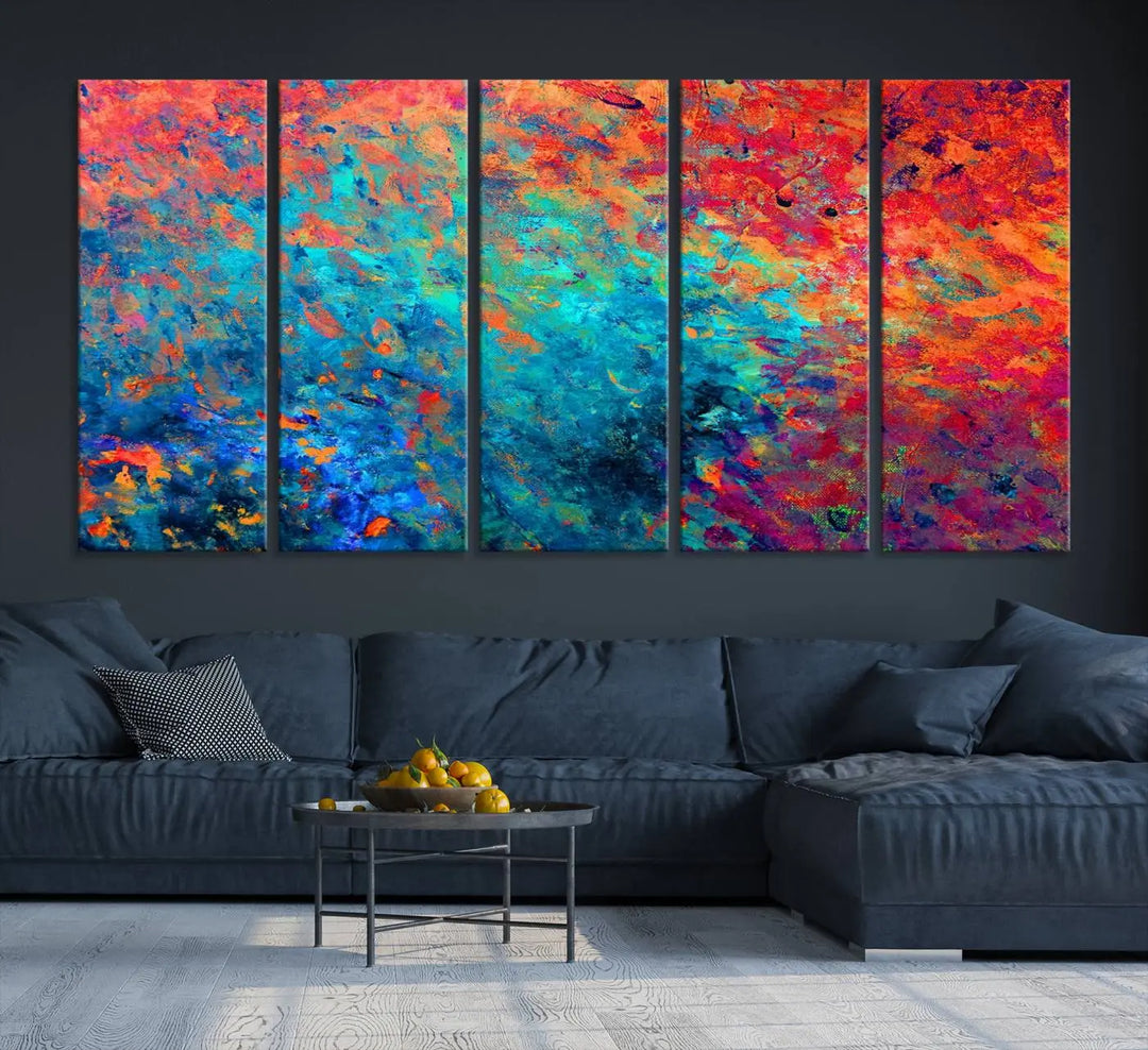 A three-part Colorful Abstract Canvas Wall Art Print, featuring vivid splashes of blue, orange, and red, is showcased on gallery-wrapped, museum-quality canvas with a UV-protective coating.